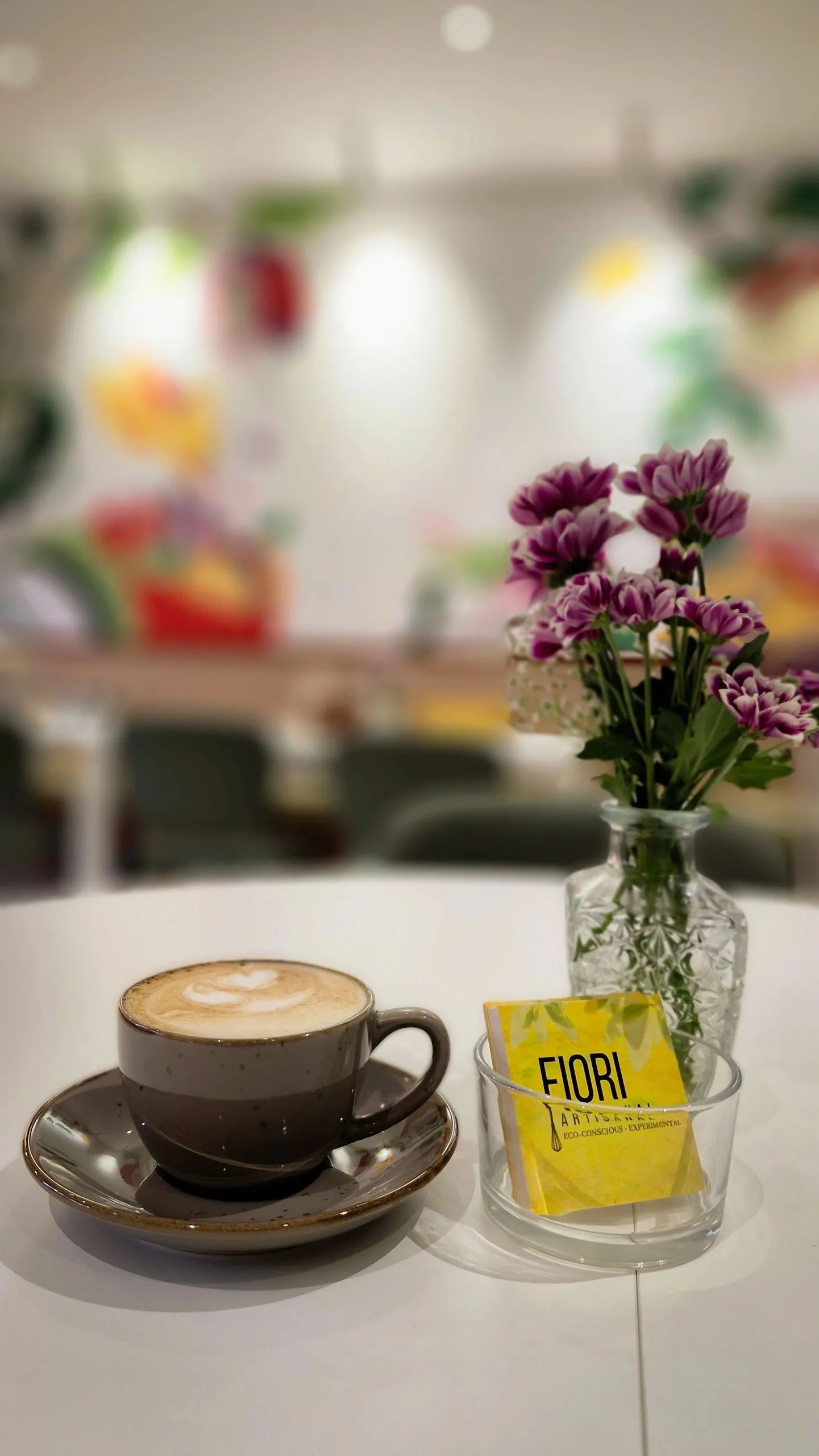Latte at Café Fiori beside fresh flowers and a Fiori menu card