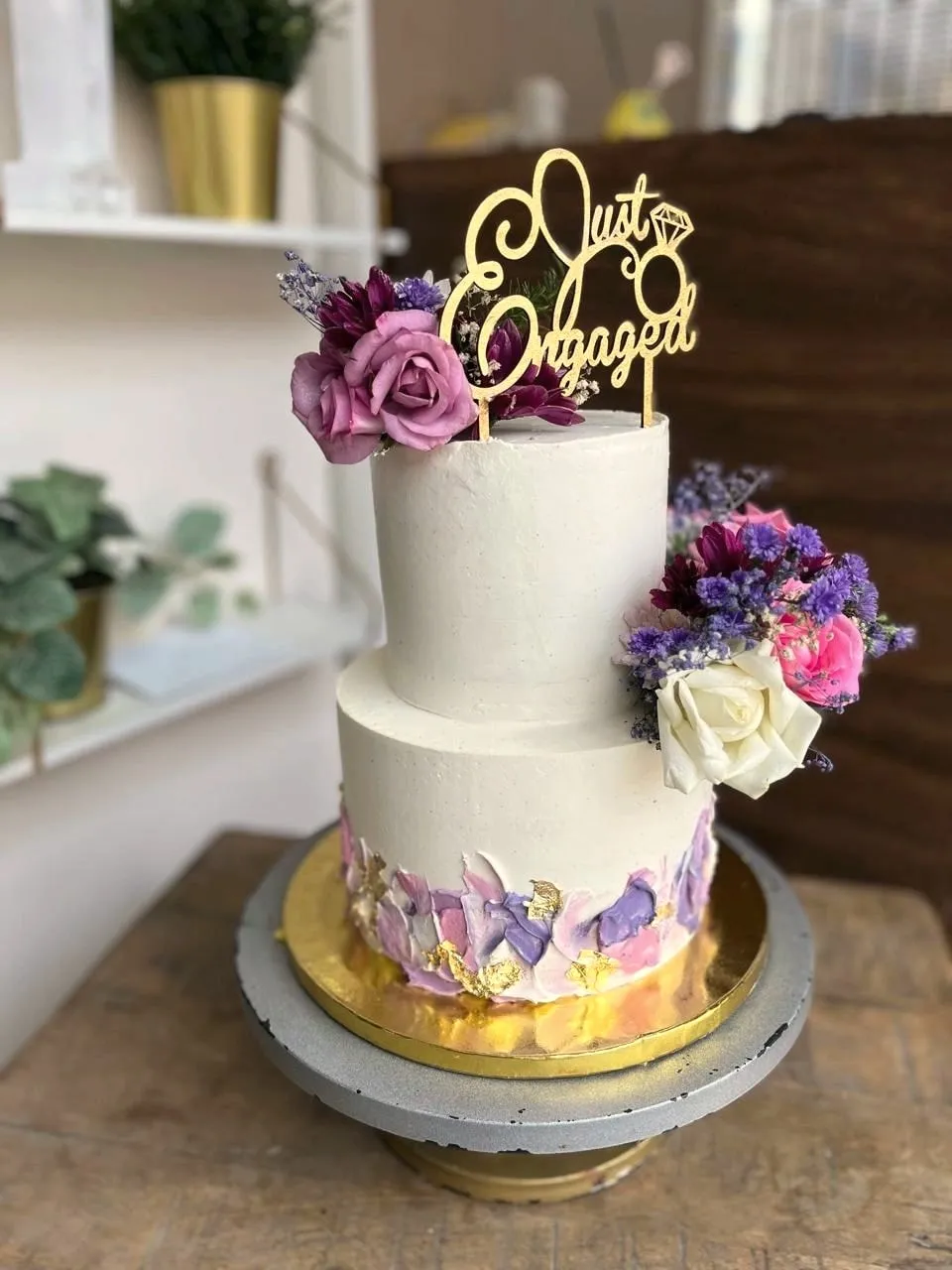 Two-tier white engagement cake with flowers