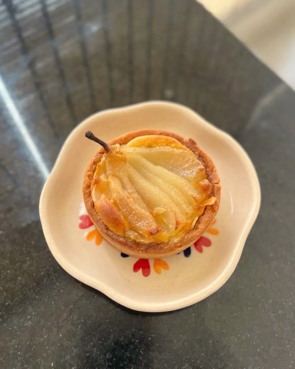 Caramelised pear tart on a hand-painted plate